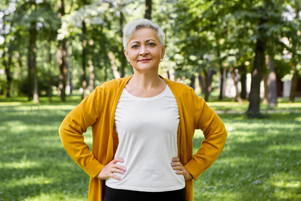 beautiful gray haired senior woman in yellow cardigan and white