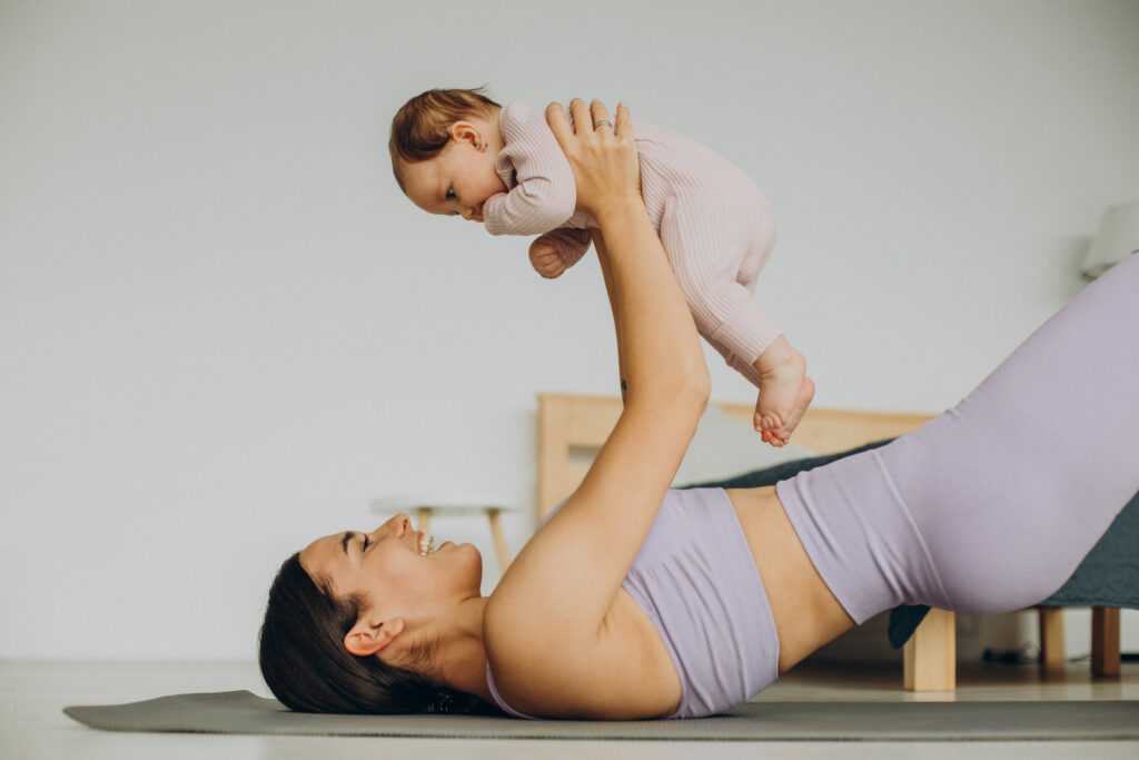 mother with her baby daughter practice yoga at home